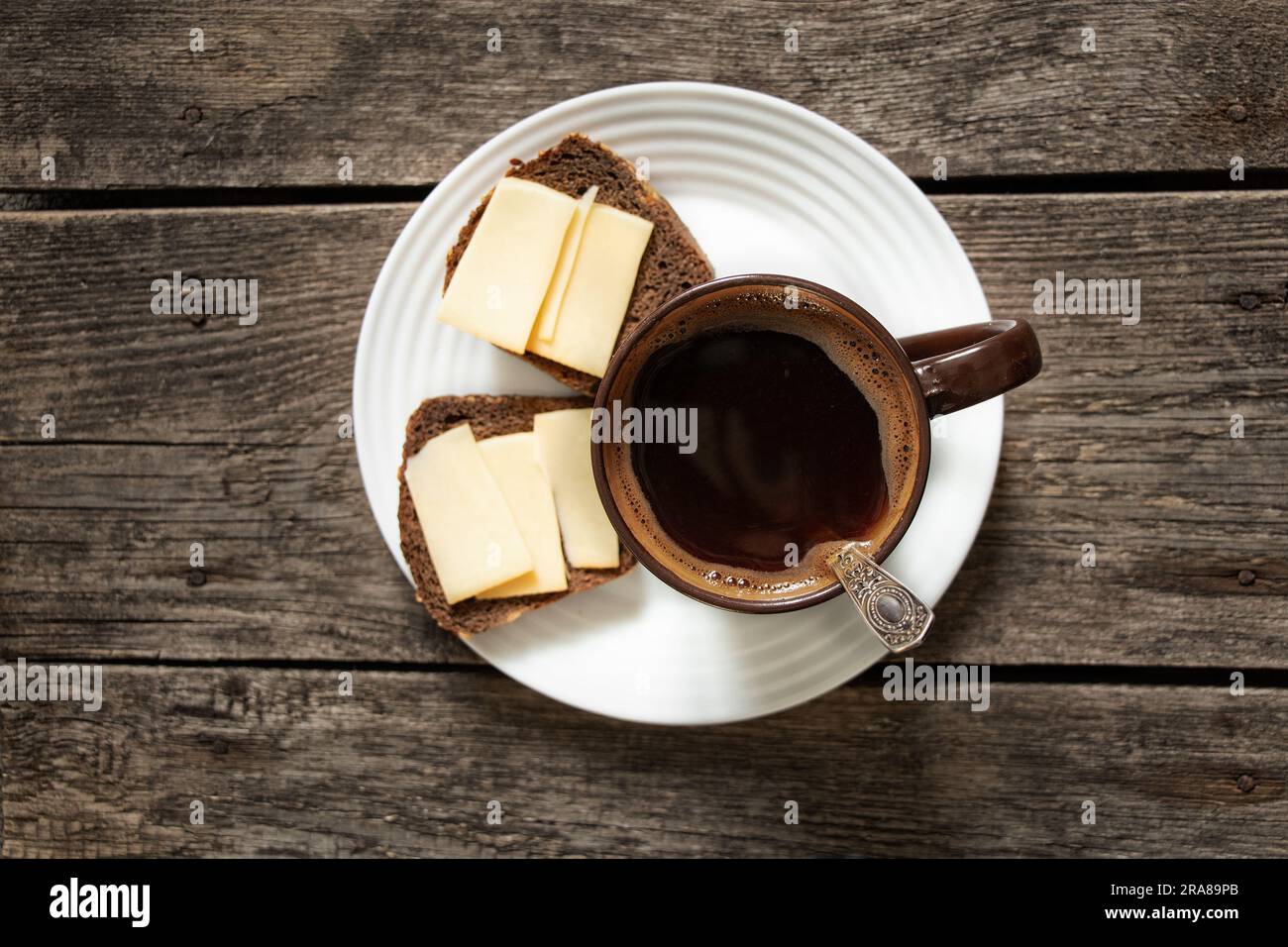 tazza di caffè e pane con formaggio su un tavolo di legno per la colazione in cucina Foto Stock