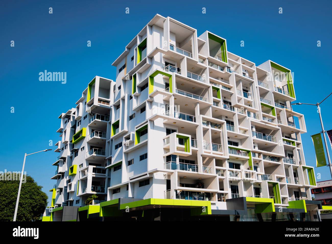 Un edificio bianco in cemento che mostra elementi di design cubici e quadrati, con accenti di verde lime, situato nel quartiere centrale degli affari della città di Darwin Foto Stock