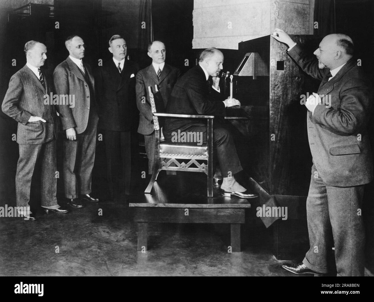 New York, New York: 8 aprile 1927 Walter Gifford, presidente AT& T, seduto ai Bell Labs di NY, parlando e vedendo il segretario del commercio Herbert Hoover a Washington, D.C. nella prima manifestazione pubblica di televisione. Con Gifford ci sono L-R, membri del Bell Lab, E. P. Clifford, Vice Presidente; H.D. Arnold. Direttore della ricerca, E.B. Craft, Vice Presidente Esecutivo, F.B. Jewett, presidente di AT&T, e Dr. Herbert Ives, membro dello staff tecnico. Foto Stock