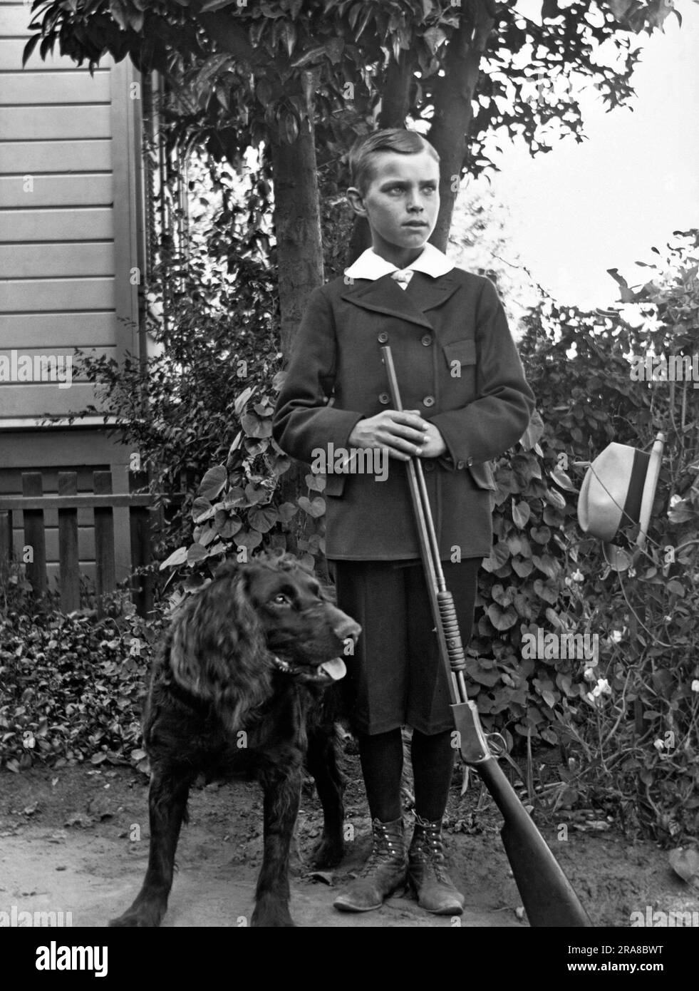 Stati Uniti d'America: 1895 circa Un adolescente ben vestito posa per un ritratto con il suo fucile e il suo cane. Foto Stock