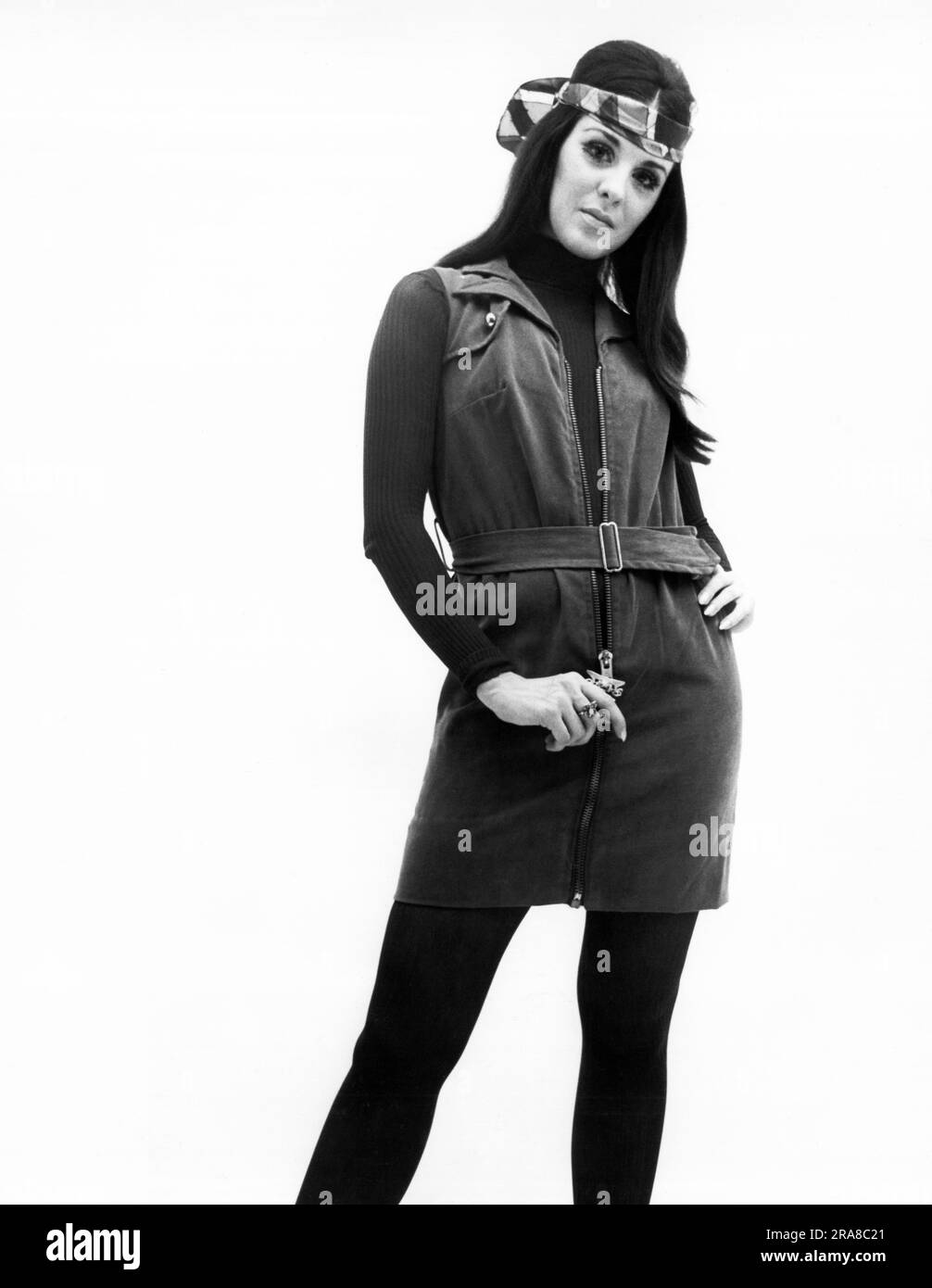 Stati Uniti: c. 1970 Una giovane donna alla moda modella un abito con cerniera indossato sopra una calza per il corpo. Foto Stock