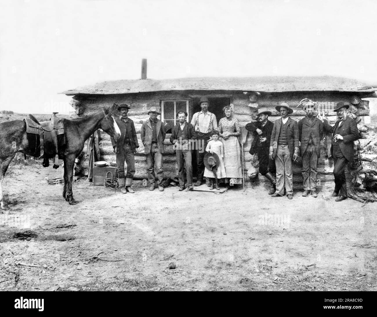 Wyoming: 1870 Una famiglia pioniera e degli amici posano per un ritratto di fronte alla loro casa sulla prateria. Foto Stock