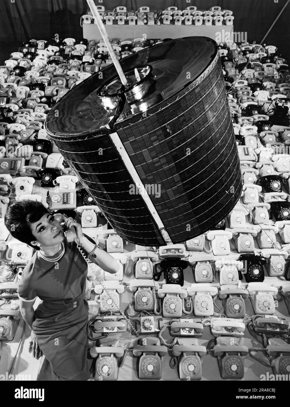 Los Angeles, California: Aprile 1965 Un dipendente della Hughes Aircraft Company utilizza uno dei 480 telefoni che il satellite per comunicazioni Intelsat 1 "Early Bird" può trasmettere in due modi conversazioni telefoniche tra Europa e Nord America. Foto Stock
