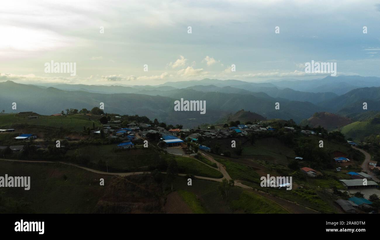 Vista aerea dello splendido cielo all'alba o al tramonto e dei villaggi rurali. Paesaggio paesaggistico nella valle nebbiosa e nuvole di montagna in thailandia. Foto Stock