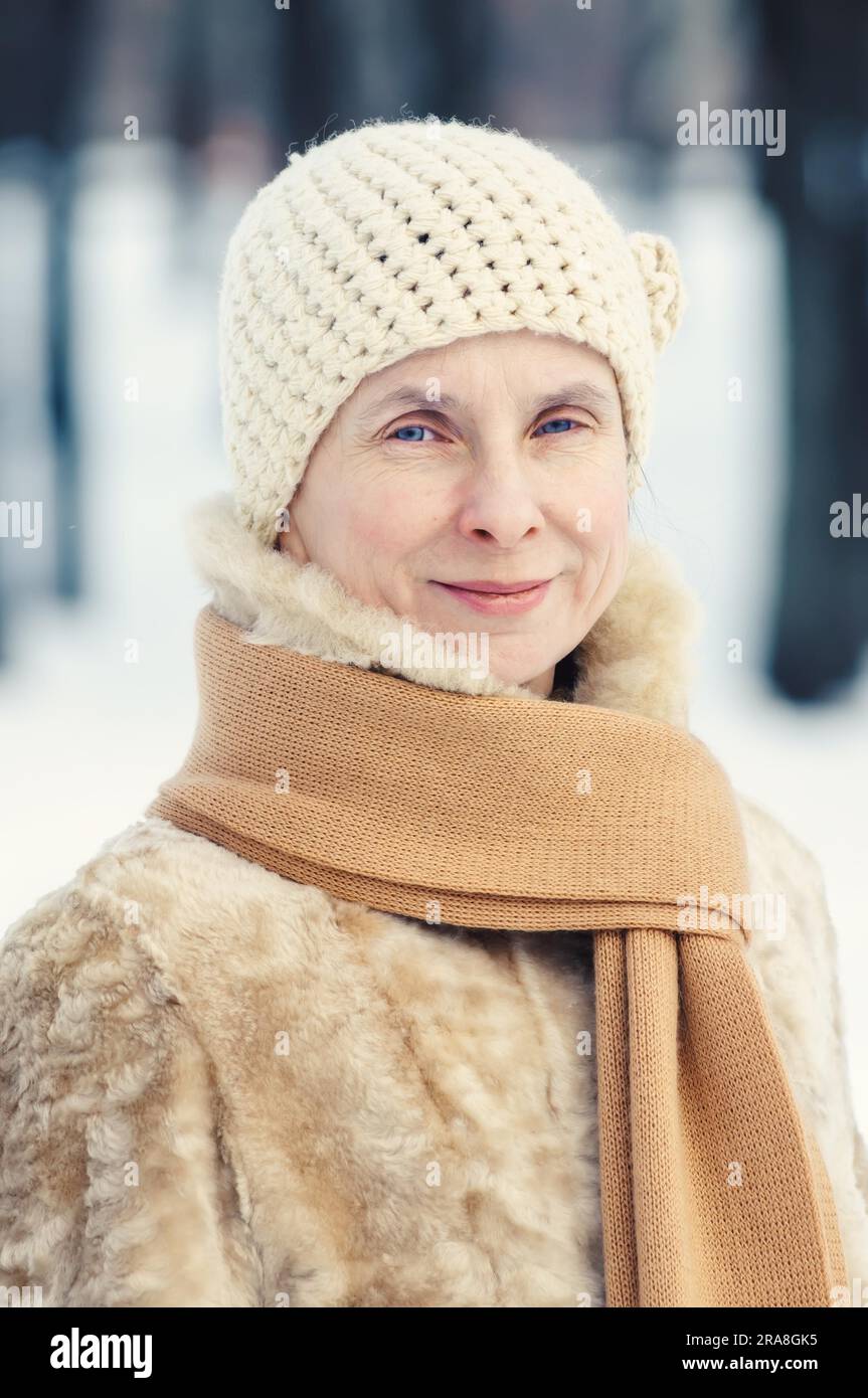 Ritratto di un naturale donna adulta con una sciarpa e un cappello di lana, all'aperto durante la stagione invernale Foto Stock