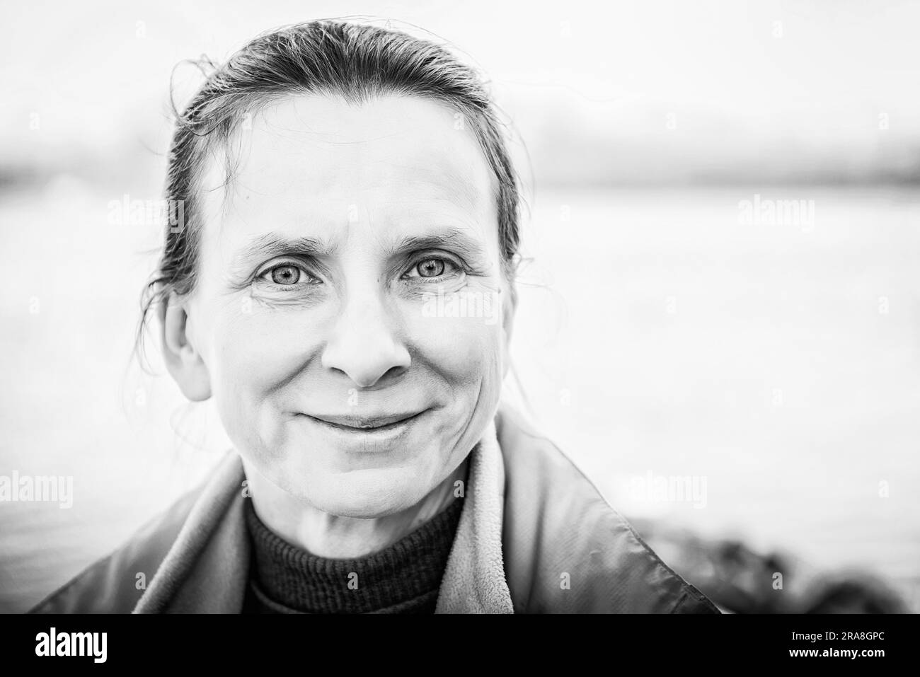 Un caldo bianco e nero ritratto di una bella donna senior vicino al fiume Foto Stock