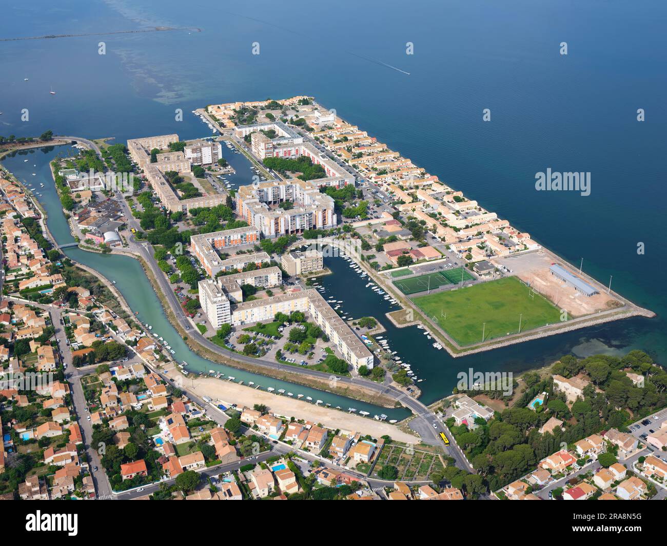 VISTA AEREA. Zona residenziale su un'isola artificiale sulla riva di Étang de Thau, l'isola si chiama Île de Thau. Sète, Hérault, Occitanie, Francia. Foto Stock