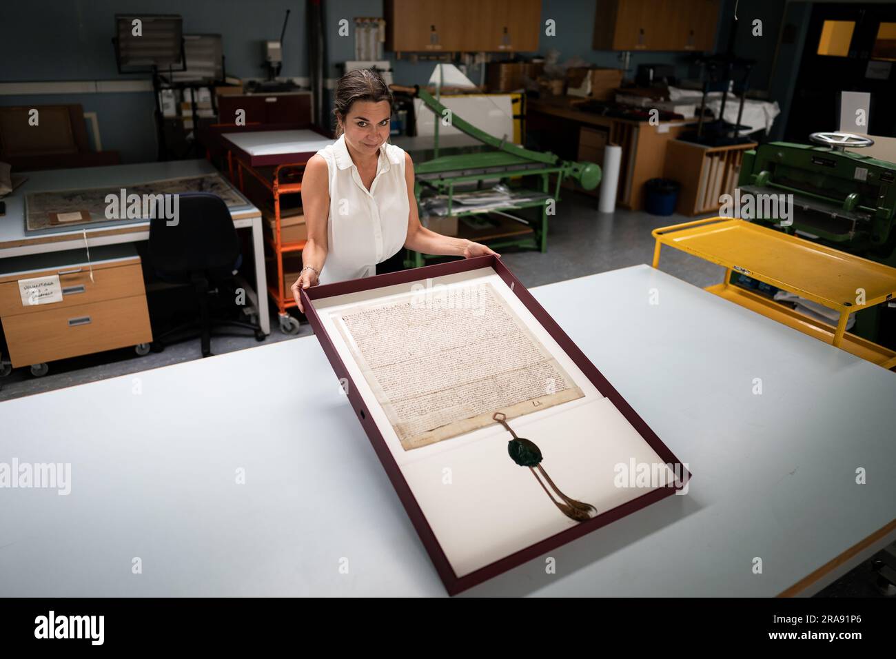 Direttore del London Metropolitan Archives (LMA) Emma Markiewicz detiene il documento Magna carta del 1297, uno dei milioni di oggetti conservati nella collezione presso il London Metropolitan Archives (LMA) nel centro di Londra. Con oltre 100 km di libri, mappe, fotografie, film e documenti che risalgono al 1067 conservati nelle stanze forti, l'LMA è il principale archivio del governo locale per l'area della Greater London, compresa la City of London ed è il più grande ufficio di registrazione della contea nel Regno Unito. Data foto: Martedì 27 giugno 2023. Foto Stock
