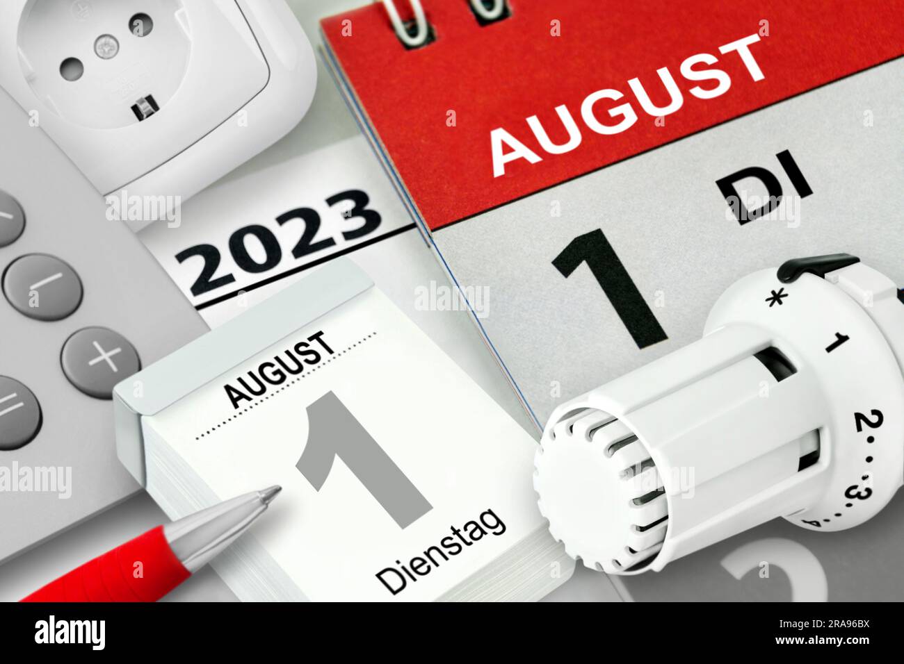 Konzept für energie und Deutscher Kalender Datum 1. Agosto 2023 Heizungsthermostat und Rechner mit Steckdose Foto Stock