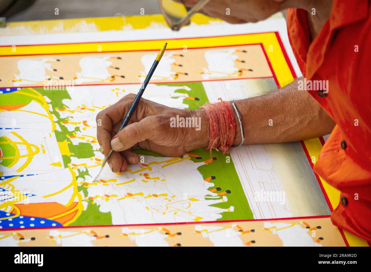 Vista della mano di un artista che dipinge un'immagine in un modo tradizionale indiano Foto Stock