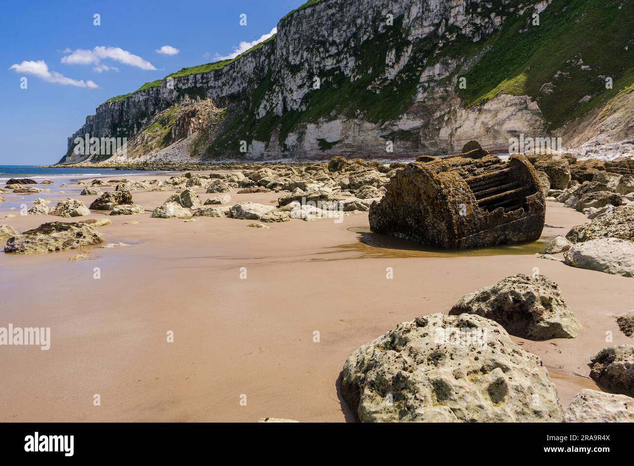 Arrugginimento della vecchia caldaia della nave ai piedi delle scogliere di gesso alla fine di Speeton Sands a Filey Bay, sulla costa del North Yorkshire Foto Stock