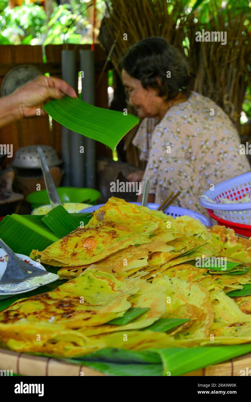 My Tho, Vietnam, 18 giugno 2023. Donna locale che prepara pancake tradizionali (Banh Xeo) presso un ristorante locale a My Tho, nella provincia di Tien Giang. Foto Stock