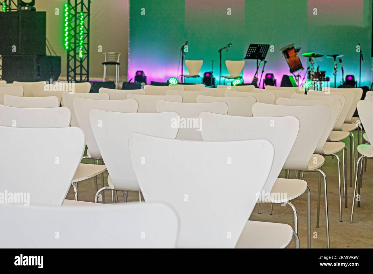 sala conferenze vuota con sedie bianche prima del concerto Foto Stock