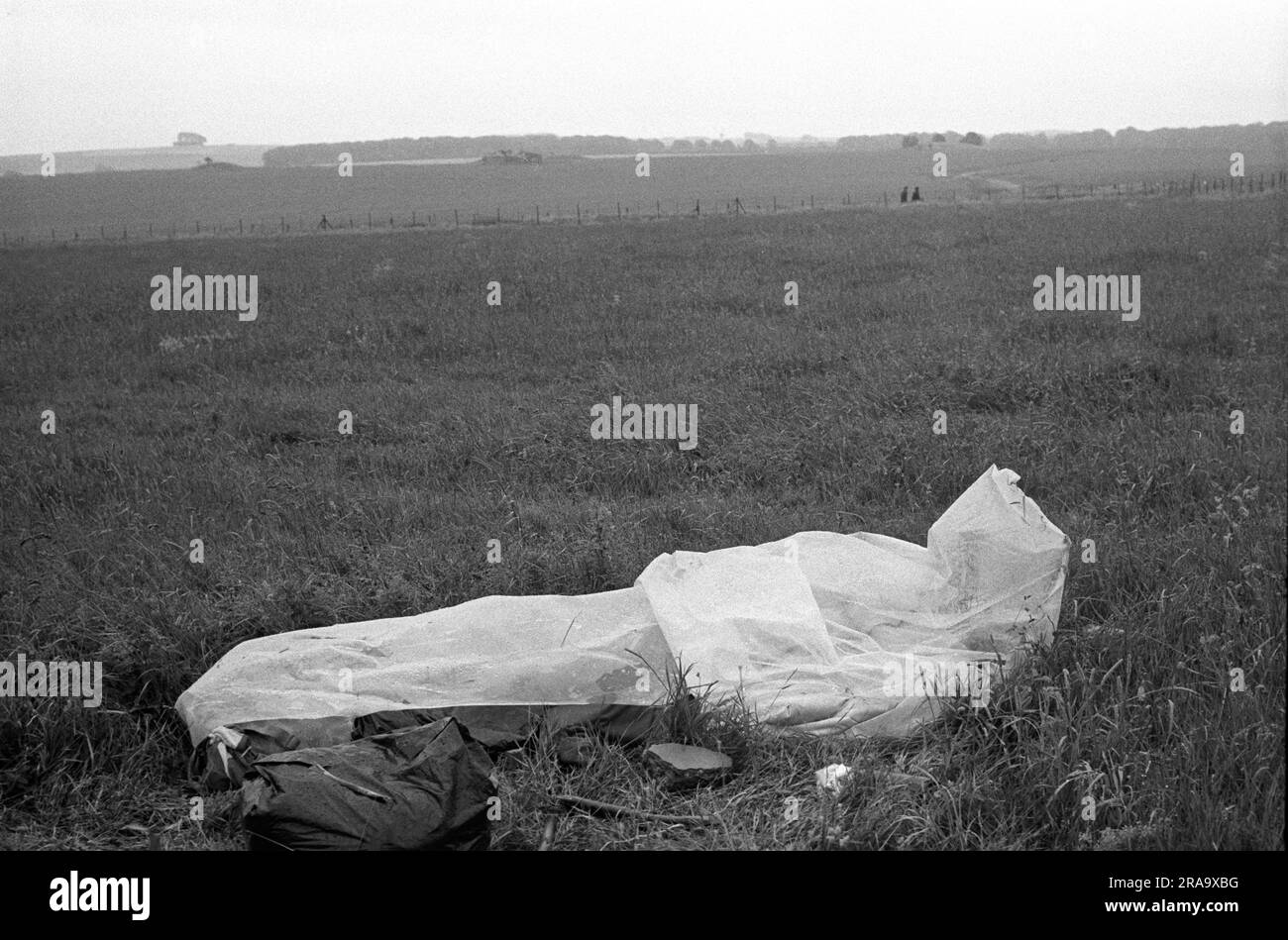 Stonehenge Free Festival al solstizio d'estate, Wiltshire, Inghilterra giugno 1976. Pioggia estiva un hippy dorme in un sacco a pelo impermeabile. 1970 UK HOMER SYKES Foto Stock