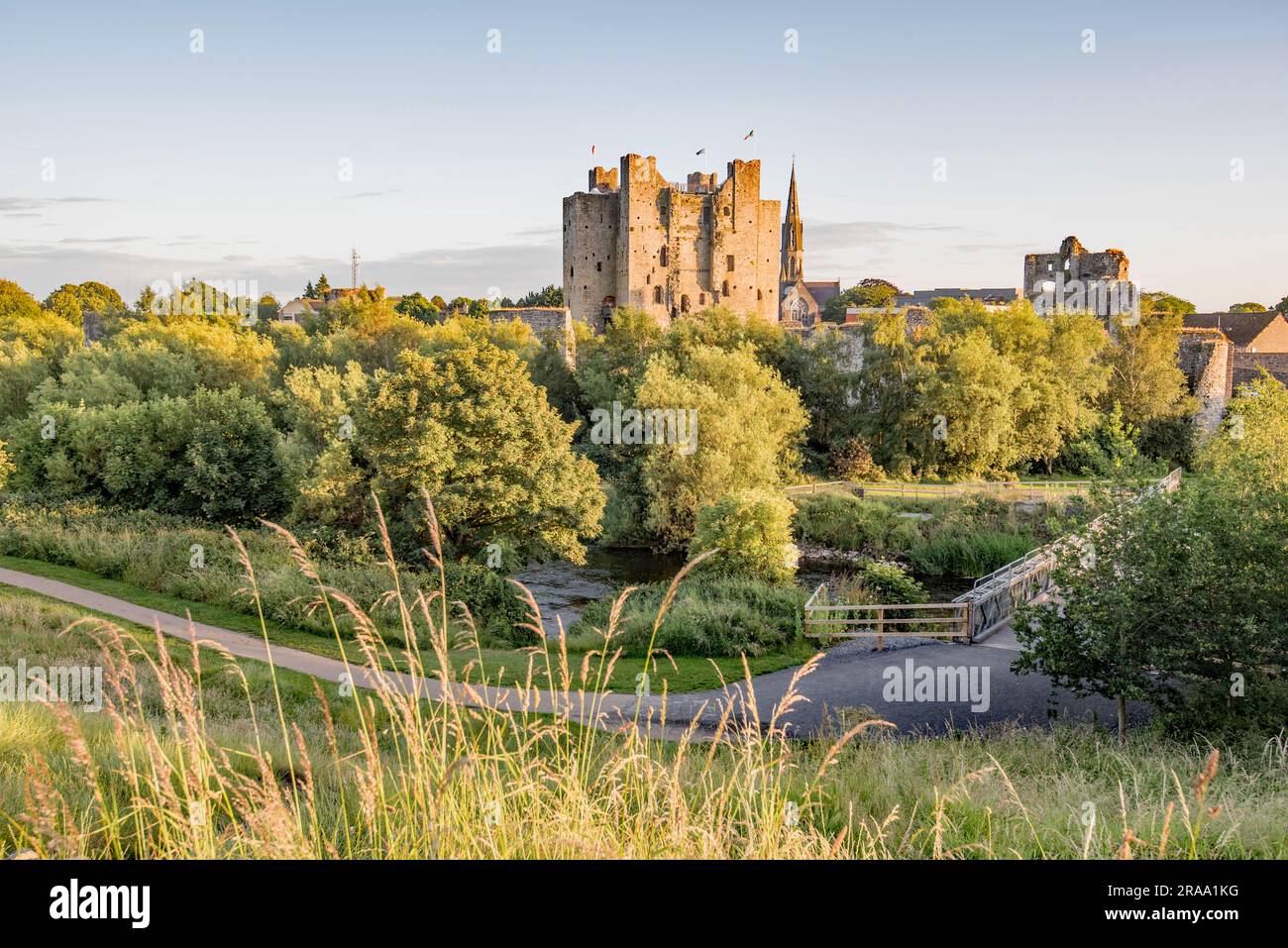 Vista sul fiume Boyne verso Trim Castle nella contea di Meath, Irlanda, con un ponte pedonale che attraversa l'acqua. Foto Stock