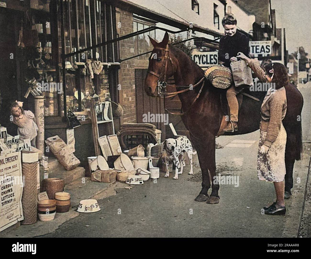 Una giovane donna compie i suoi acquisti a cavallo durante i primi mesi della seconda guerra mondiale. Data: 1939 Foto Stock