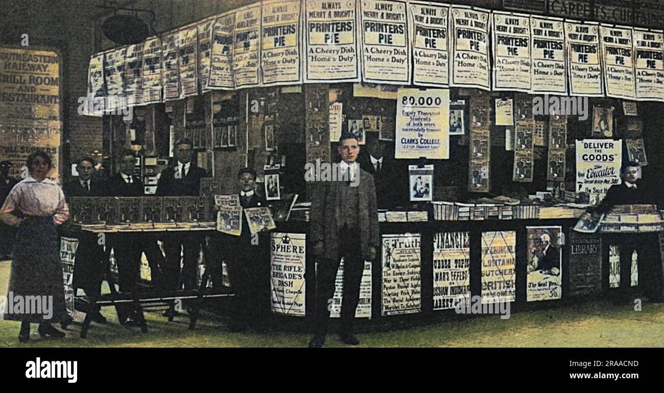 La bancarella di W. H. Smith alla stazione di Cannon Street, Londra, mostra in particolare la mostra della rivista Printers' Pie, una pubblicazione di beneficenza biennale prodotta da Hugh Spottiswoode, contribuì con illustratori e scrittori famosi e venduta in aiuto di un'organizzazione di beneficenza per gli stampatori. Altri poster che pubblicizzano riviste popolari del giorno, tra cui The Sphere e Truth. Data: 1915 Foto Stock