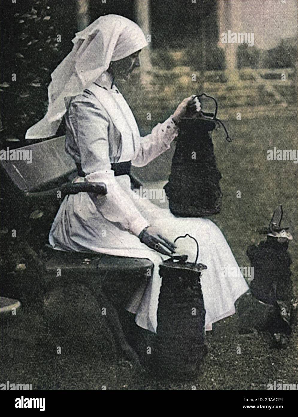 Lady Stradbroke, ex Helena Fraser e moglie di George Rous, III conte di Stradbroke, raffigurata in uniforme da infermiera nella casa di famiglia di Henham Hall nel Suffolk, contemplando le bombe sganciate da aerei tedeschi nell'aprile 1915. La casa fu convertita in ospedale militare durante la prima guerra mondiale e ricevette convogli di soldati feriti direttamente dalla Francia, che furono passati alla Croce Rossa una volta sufficientemente bene. Lady Stradbroke si assunse la sola carica come matrona e supervisionò efficacemente l'ospedale. Henham Hall fu demolita nel 1953. Data: 1915 Foto Stock