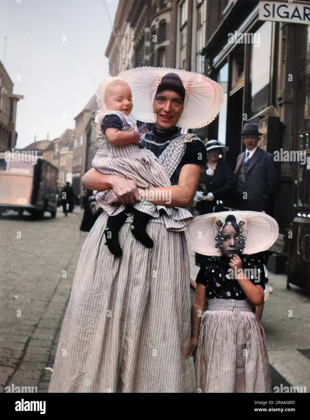 Una donna e due bambini in abito tradizionale in una strada a Middleburg, Olanda. Data: 1936 Foto Stock