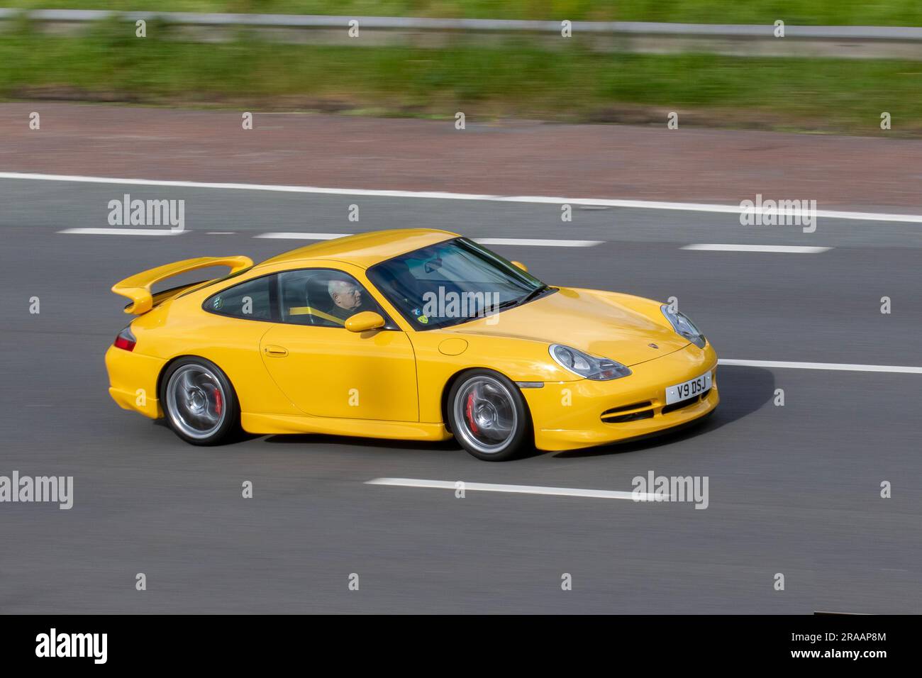 2000 Porsche 911 GT3 Yellow Car Coupe benzina benzina 3600 cc, supercar per tutti i giorni incentrata su pista con motore da 3,6 litri a sei cilindri piatti "Mezger"; viaggia a velocità sostenuta sull'autostrada M6 a Greater Manchester, Regno Unito Foto Stock