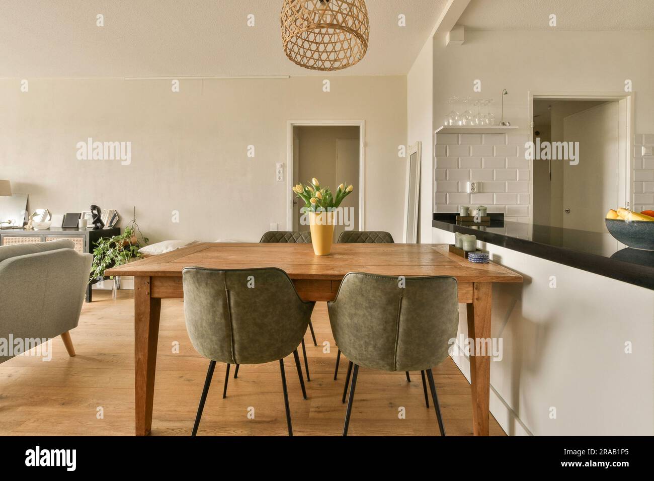 una sala da pranzo con sedie e un tavolo davanti ai divani che si affacciano verso l'area cucina Foto Stock
