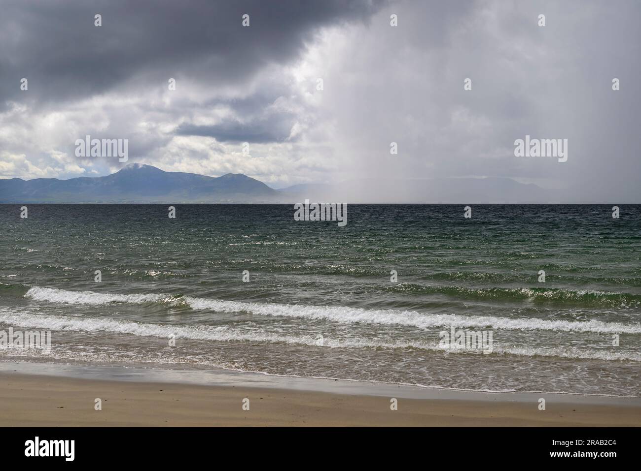 Spettacolare paesaggio sul mare con nuvole di pioggia e montagne, Irlanda a giugno Foto Stock