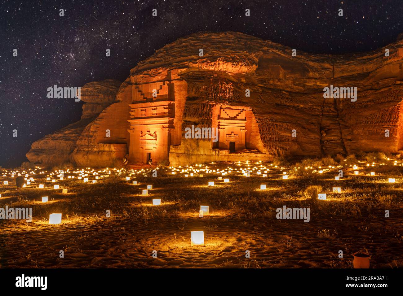 Cielo stellato sulle antiche tombe nabatee della città di Mada'in Salih Hegra illuminata, panorama notturno, al Ula, Arabia Saudita Foto Stock