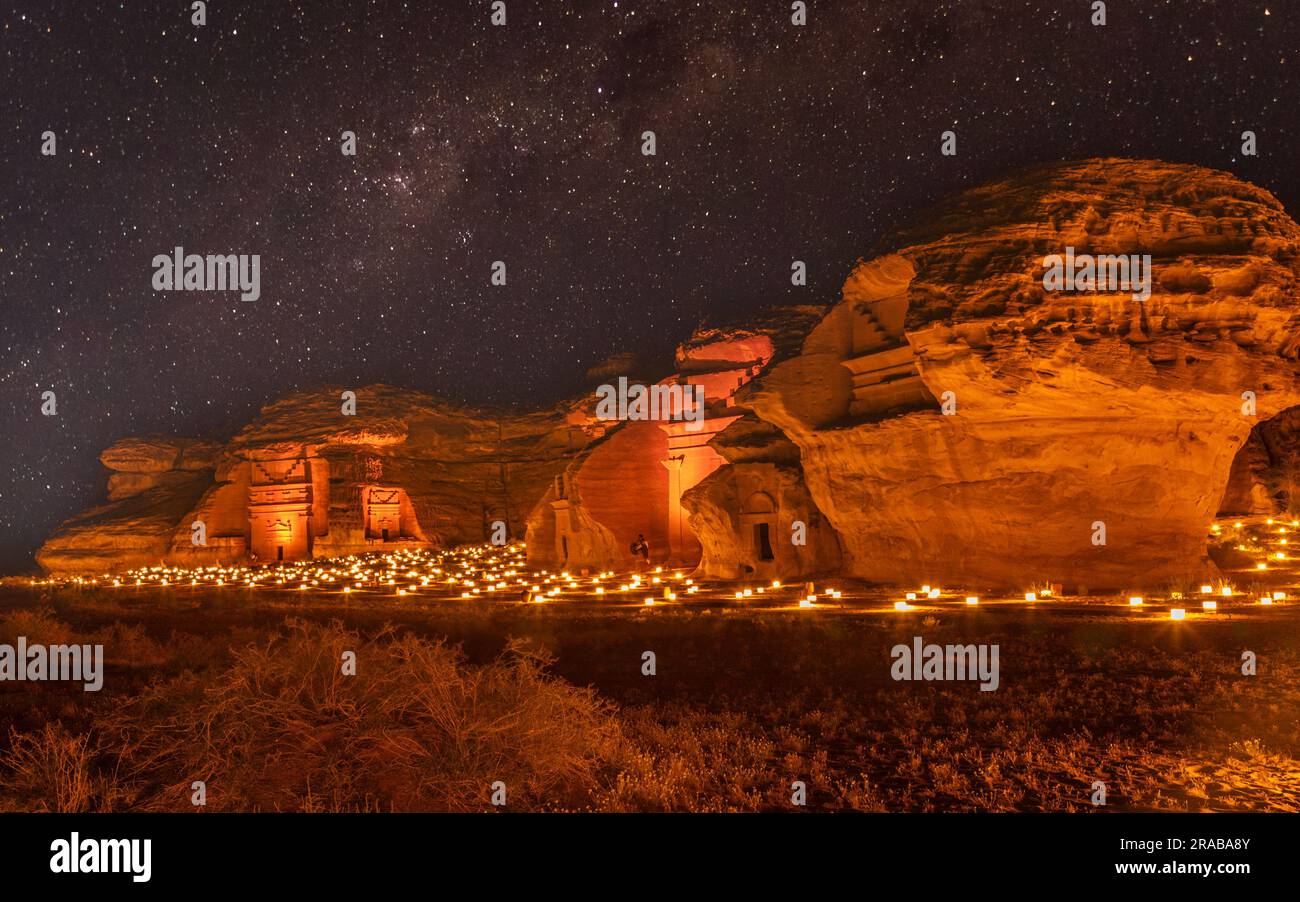 Cielo stellato sulle antiche tombe nabatee della città di Hegra illuminate, panorama notturno, al Ula, Arabia Saudita Foto Stock
