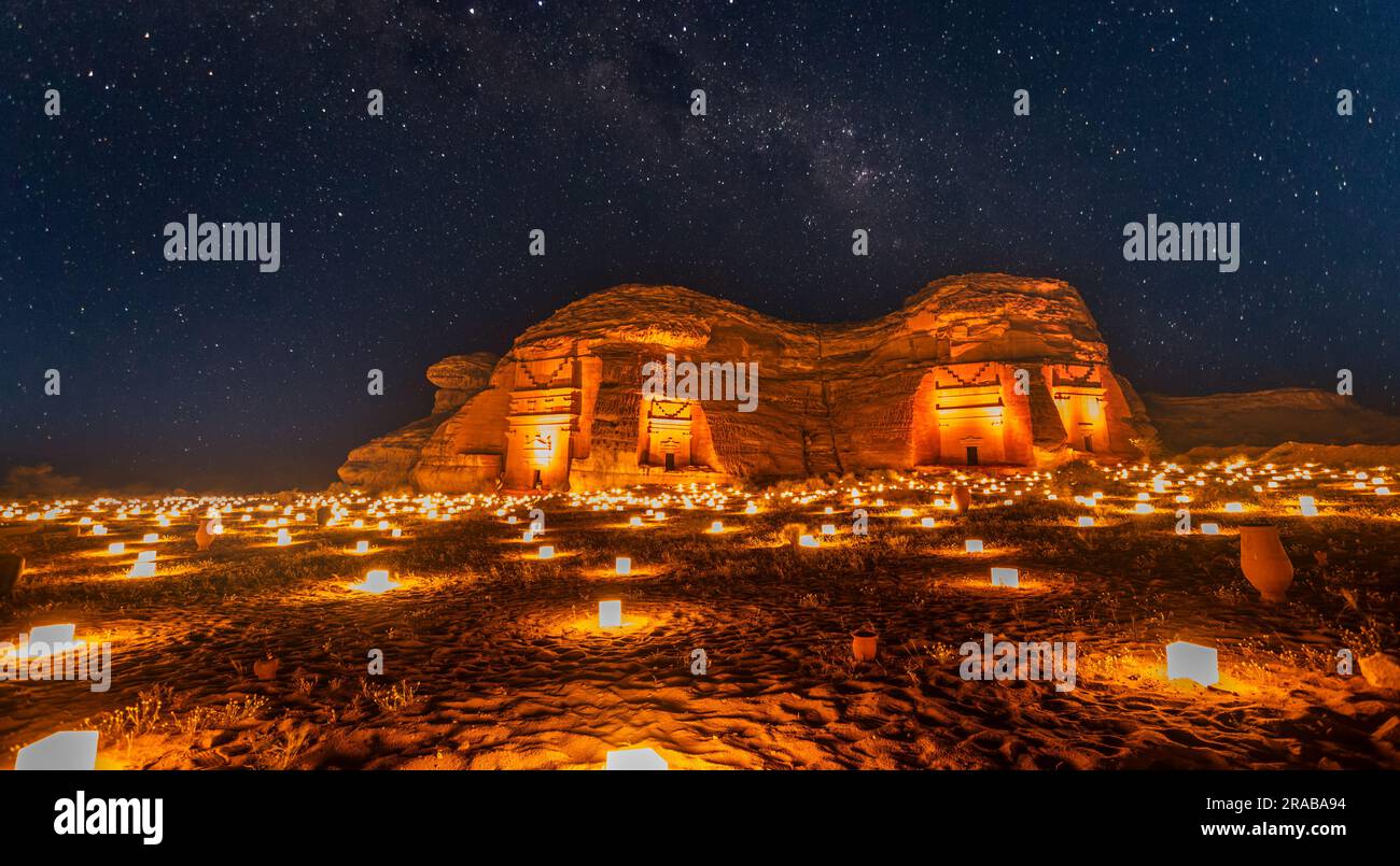 Cielo stellato sulle antiche tombe nabatee della città di Hegra illuminate, panorama notturno, al Ula, Arabia Saudita Foto Stock