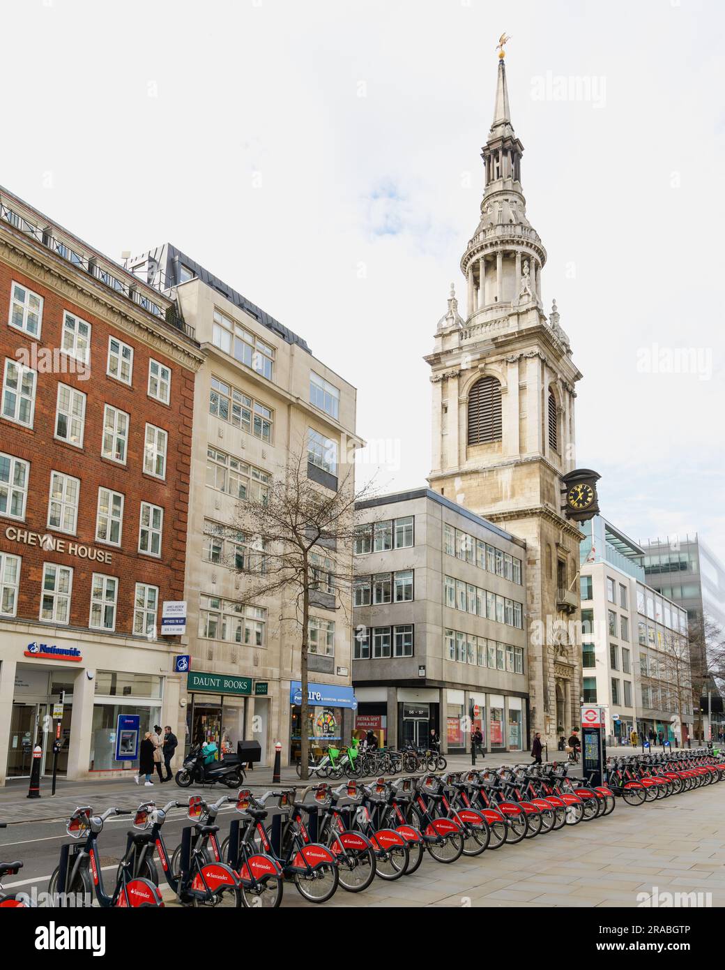 Londra, Regno Unito - 16 marzo 2023; il campanile della chiesa di St Mary le Bow si innalza sopra la fila di biciclette Santander a Londra Foto Stock