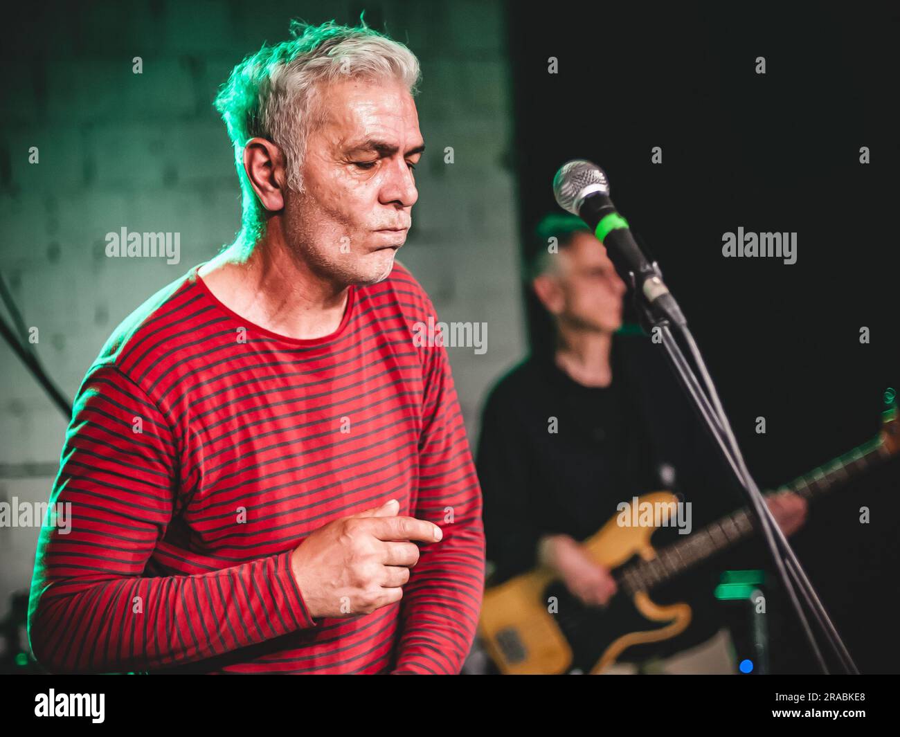 Ritratto ravvicinato del cantante artista durante una performance dal vivo su un palco. Gruppo musicale punk rock Foto Stock