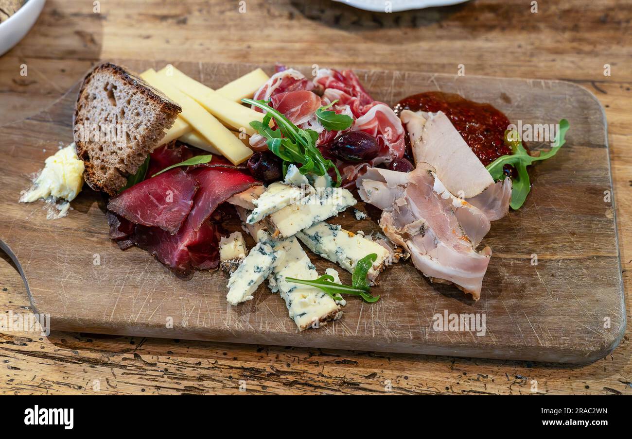 Tavola di legno con una varietà di formaggi e carni a Berlino, Germania Foto Stock