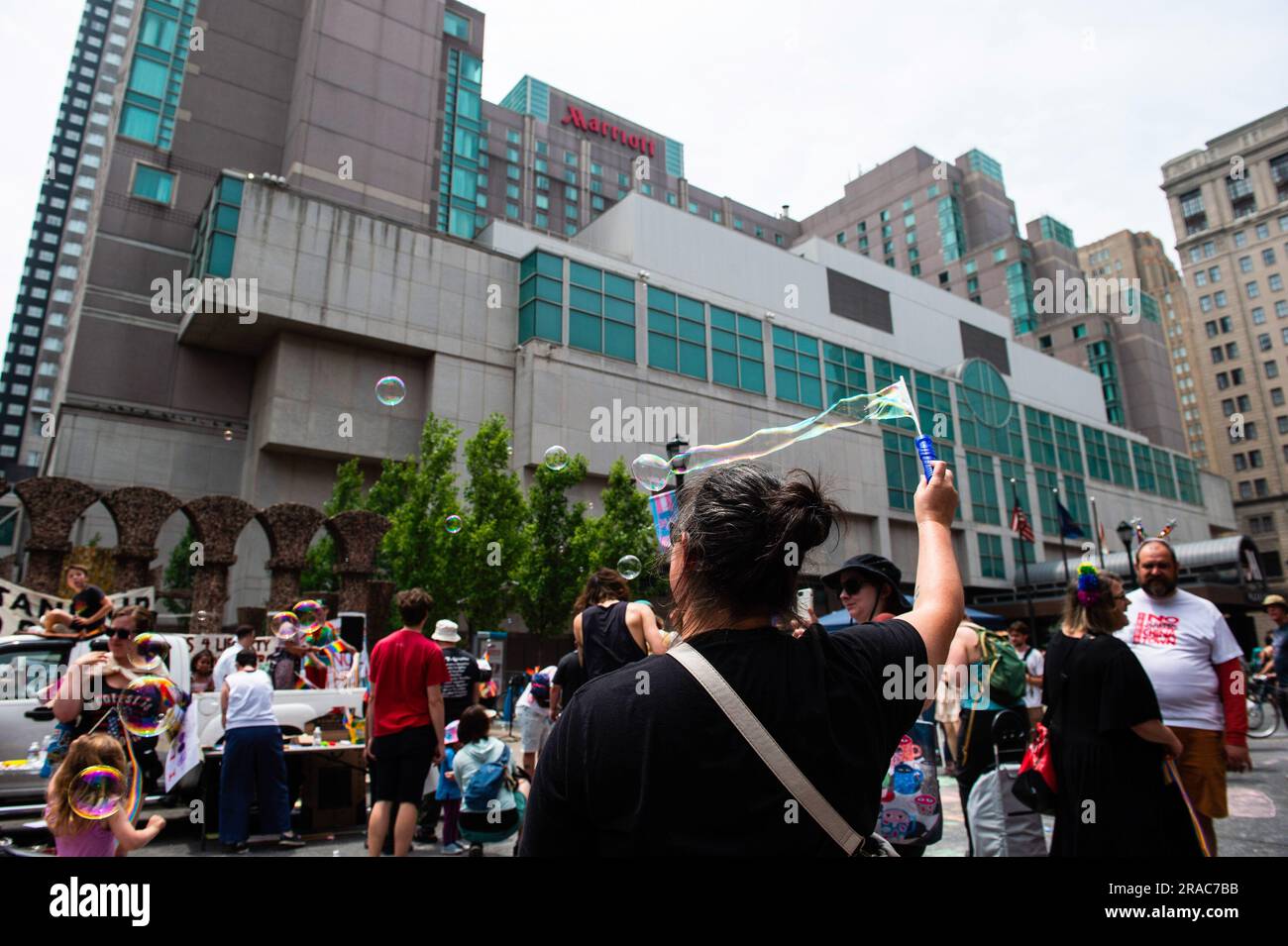 Un manifestante lancia una bacchetta d'aria nell'aria durante una protesta tenuta dal movimento dei Philly Children contro Moms for Liberty nel centro di Philadelphia. MUM's for Liberty, un gruppo del 2021 per combattere i mandati COVID-19, tenne il loro summit annuale a Philadelphia, in Pennsylvania, e furono incontrati da manifestanti che protestavano contro l'evento e le azioni di Mom's for Liberty. Il gruppo che è designato dal Southern Poverty Law Center come gruppo di odio, è stato una voce vocale nella retorica anti-LGBT e la spinta a vietare alcuni libri dalle scuole e dalle biblioteche. Foto Stock