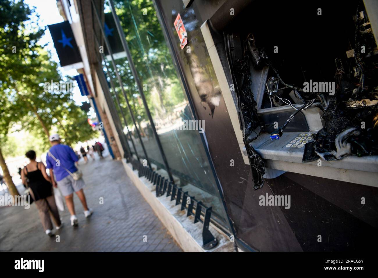 Marsiglia, Francia. 2 luglio 2023. Mano nella mano, un paio fa una passeggiata davanti ai resti di un bancomat esploso. Un ragazzo di 17 anni è stato ucciso dalla polizia a Nanterre, innescando rivolte diffuse in tutto il paese. A Marsiglia, la città si svegliò in apprensione dopo la quinta notte consecutiva di rivolte. Credito: SOPA Images Limited/Alamy Live News Foto Stock