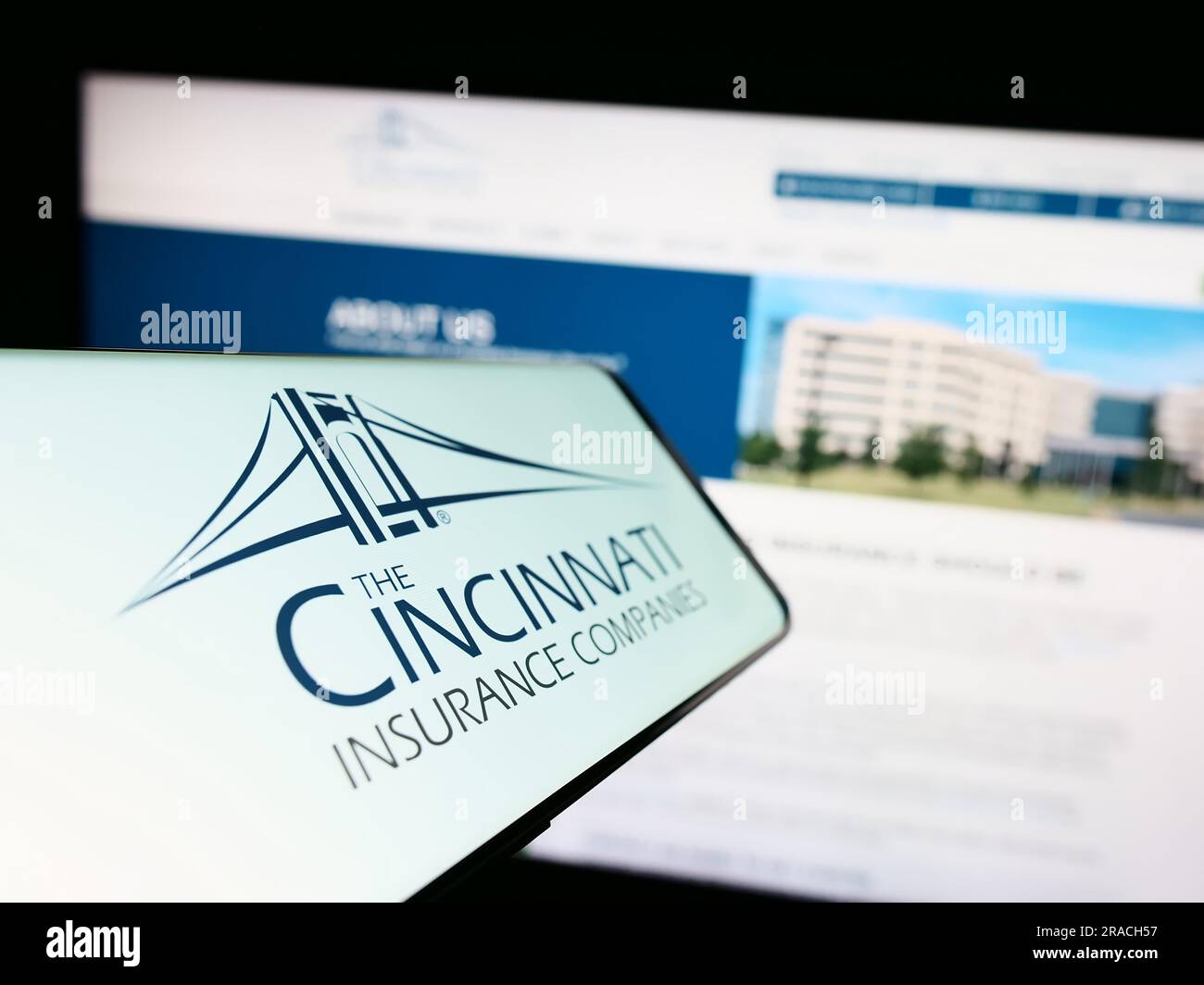 Cellulare con logo della società americana Cincinnati Financial Corporation sullo schermo davanti al sito Web. Mettere a fuoco il display centrale sinistro del telefono. Foto Stock