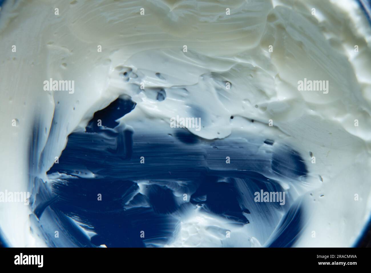 crema per le mani bianca su sfondo blu da vicino Foto Stock