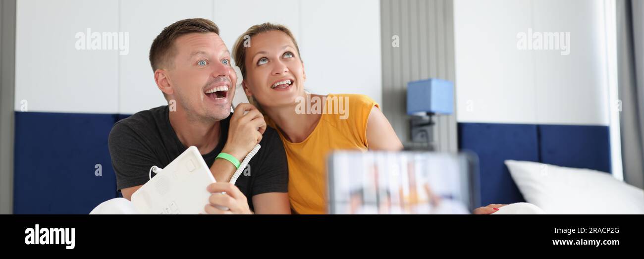 Felice coppia sorridente che registra video a letto sullo smartphone Foto Stock