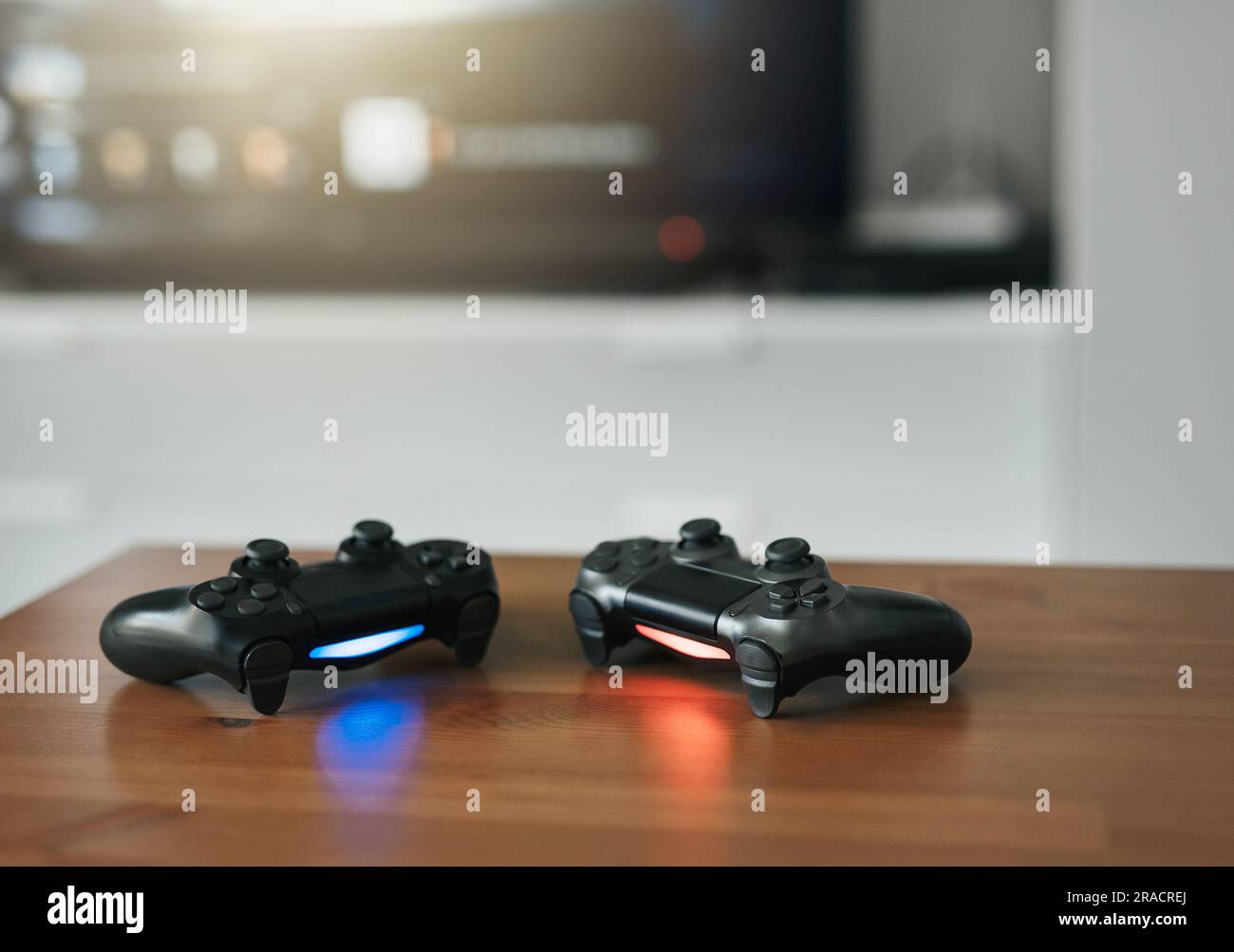 Console per videogiochi. Vista dall'alto un equipaggiamento da gioco sullo sfondo del tavolo. Joystick o gamepad su un tavolo. Foto Stock