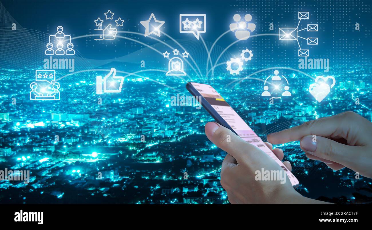 Le mani di una donna con smartphone e icone di social networking sullo sfondo della città notturna. Concetto di comunicazione mobile globale e di social network Foto Stock