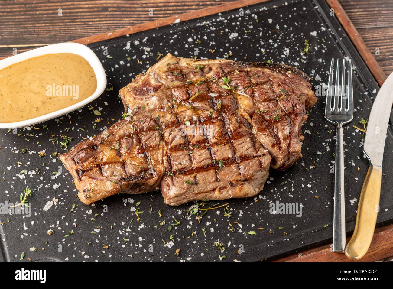 Bistecca di tomahawk alla griglia su tagliere di pietra nel ristorante grill Foto Stock