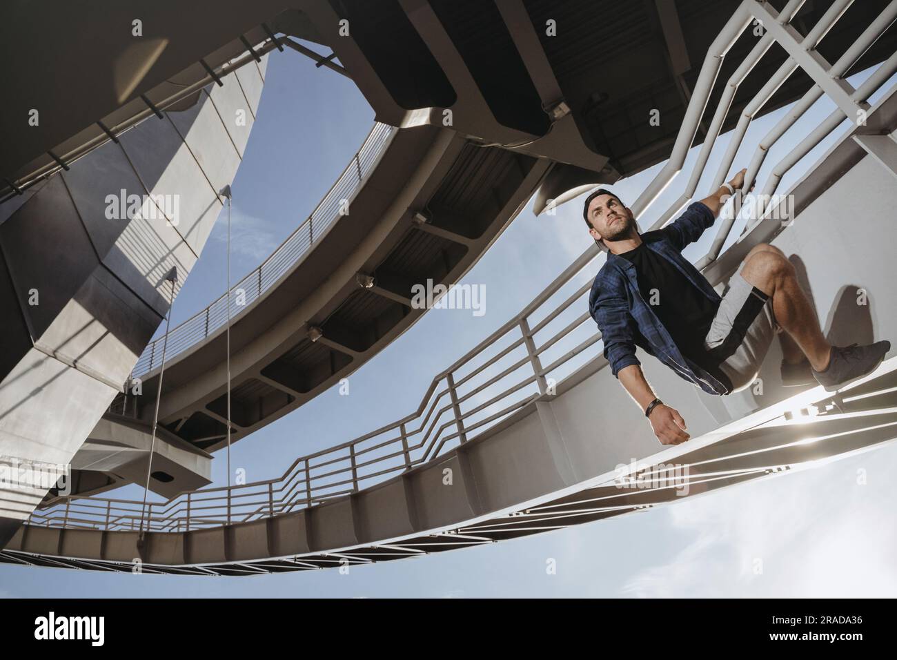Ritratto dell'atleta parkour che sale sul ponte. Freerunning in città Foto Stock