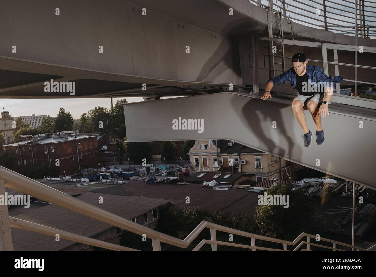 Atleta freerun che fa un salto spaventoso da un ponte alto. Parcheggio pericoloso Foto Stock