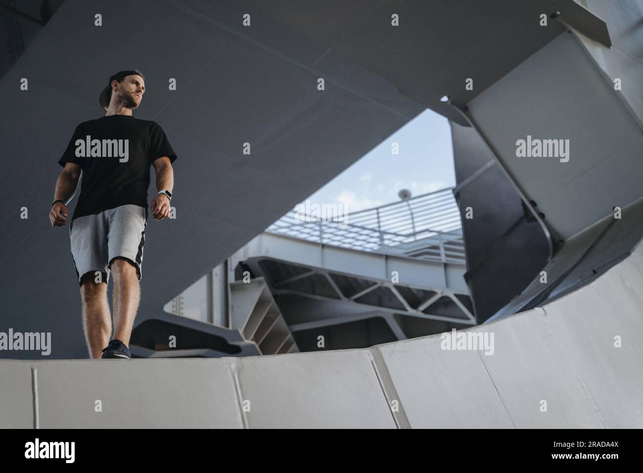 Ritratto di un atleta freerunning in piedi sul bordo della struttura metallica. Sto cercando un posto per la tua pubblicità Foto Stock