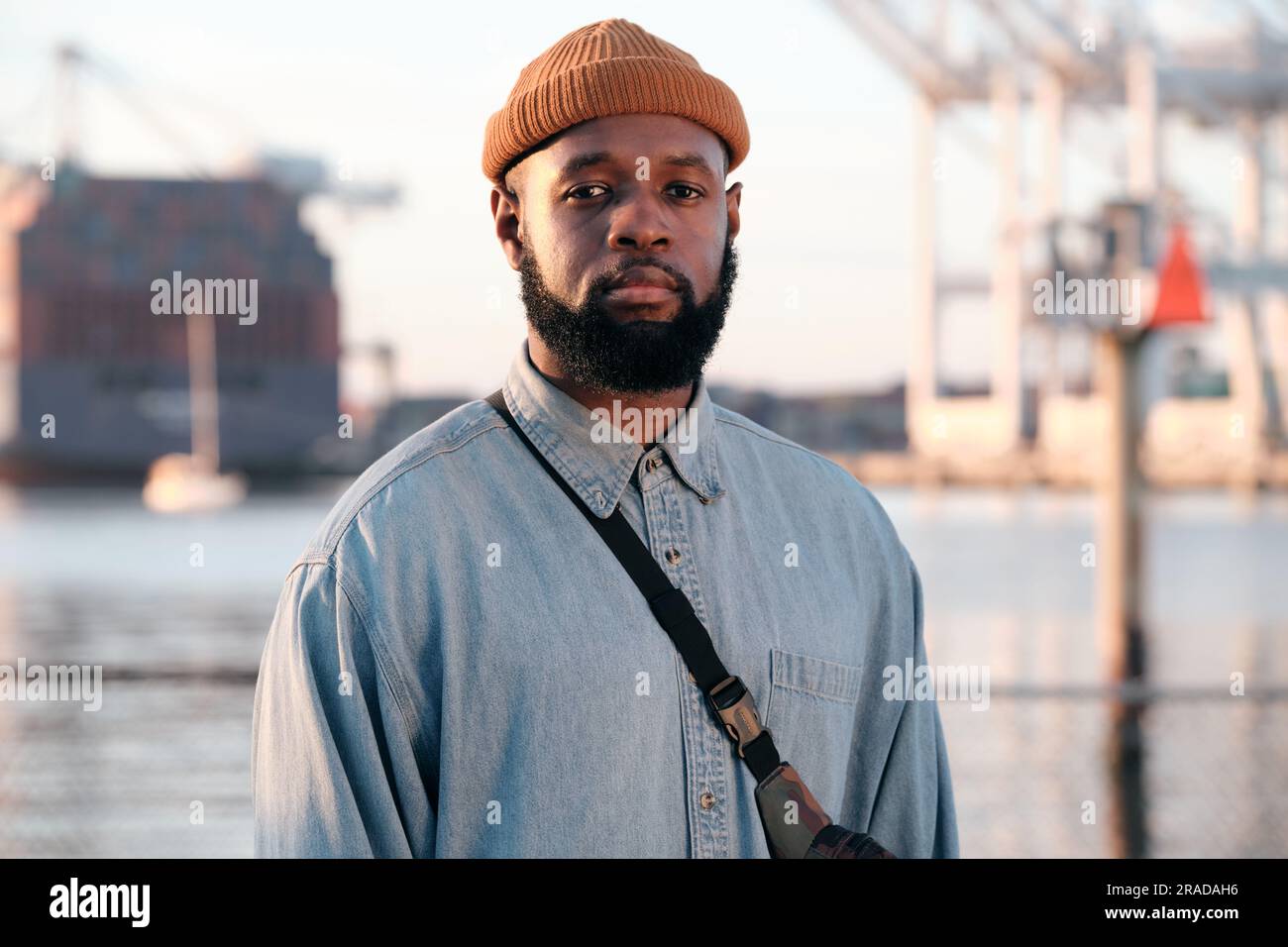 Solitudine: Uomo afro-americano in piedi da solo vicino a un canale Foto Stock