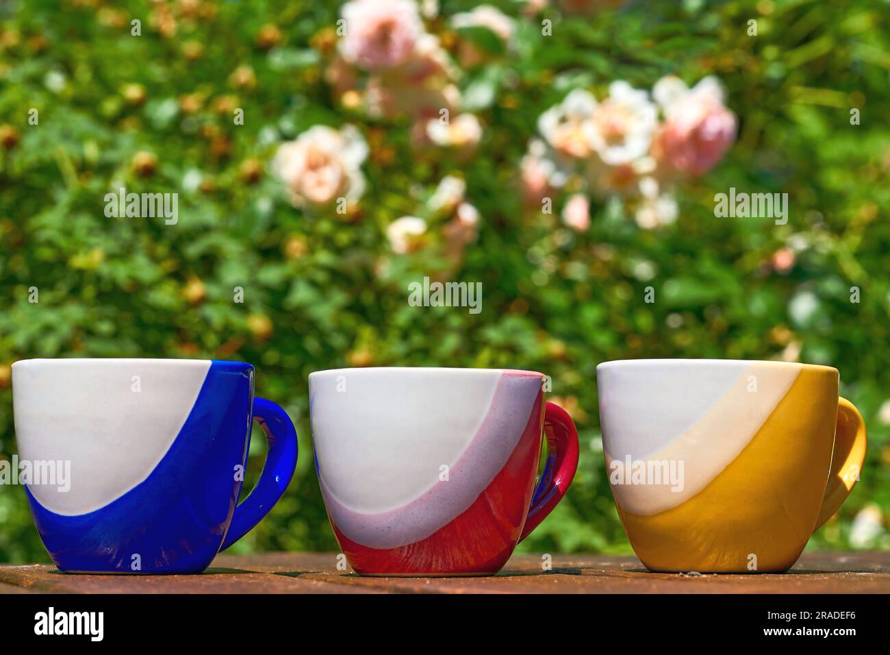 Teatime. tazze di tè e caffè e fiori nel verde su una superficie di legno Foto Stock