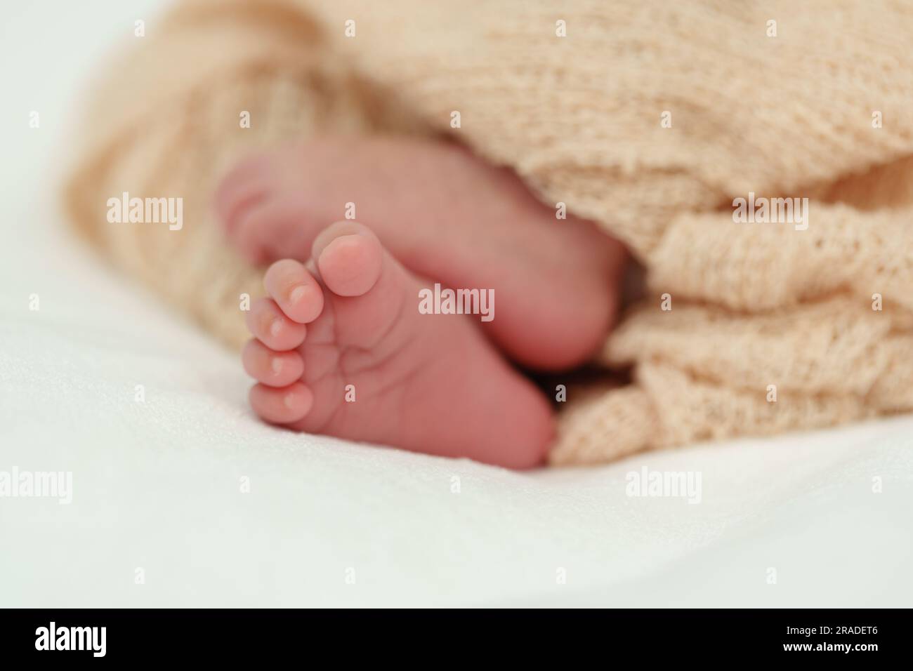 primo piano dei piedi del neonato su un letto Foto Stock