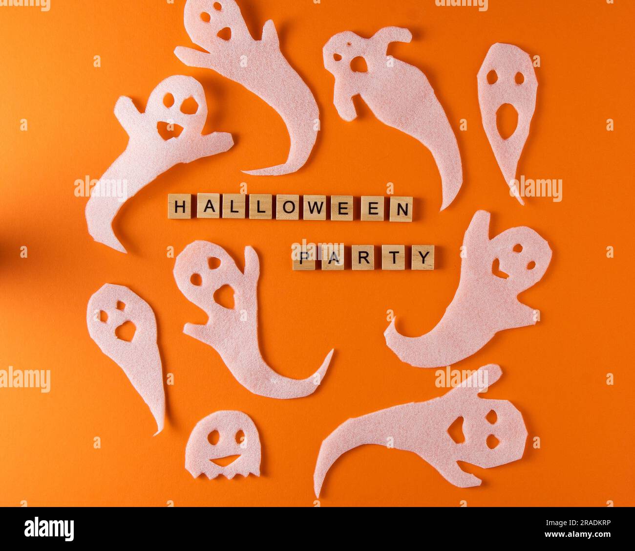 Fantasmi bianchi per la festa di Halloween. Immagine fantasma della carta di avvolgimento su sfondo arancione vista dall'alto. Fumetto Creepy Whisper. Fai-da-te fatto a mano. Impostare i caratteri boo. Parola frase di legno della lettera. Foto Stock