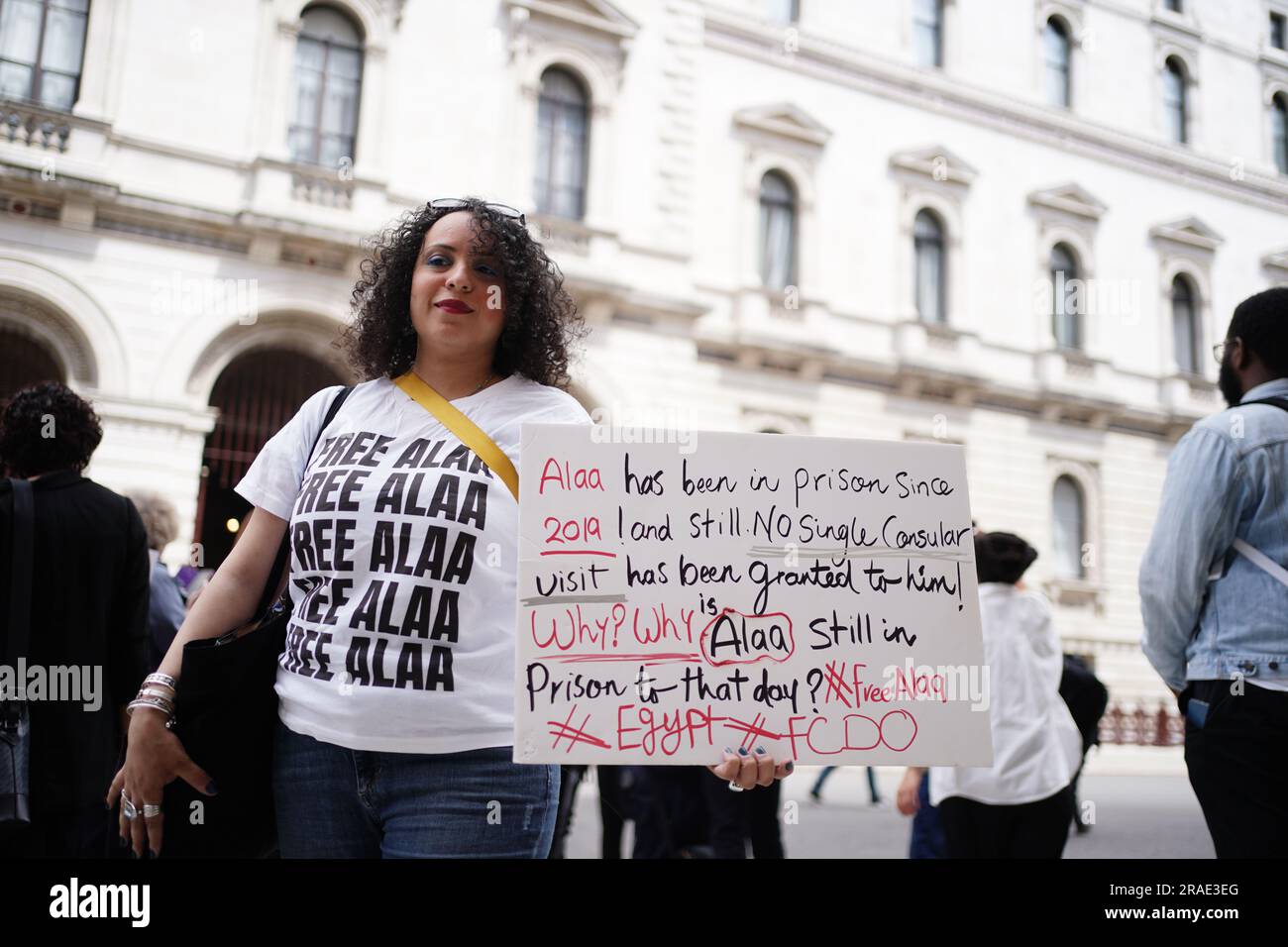 Persone in una veglia di Amnesty International per la scrittrice anglo-egiziana Alaa Abd el-Fattah, l'attivista pro-democrazia incarcerata in Egitto per la maggior parte degli ultimi dieci anni, al di fuori del Foreign, Commonwealth and Development Office (FCDO) a Westminster, Londra, Esortando il governo del Regno Unito a premere con urgenza per il suo rilascio dal carcere in Egitto. Data immagine: Lunedì 3 luglio 2023. Foto Stock