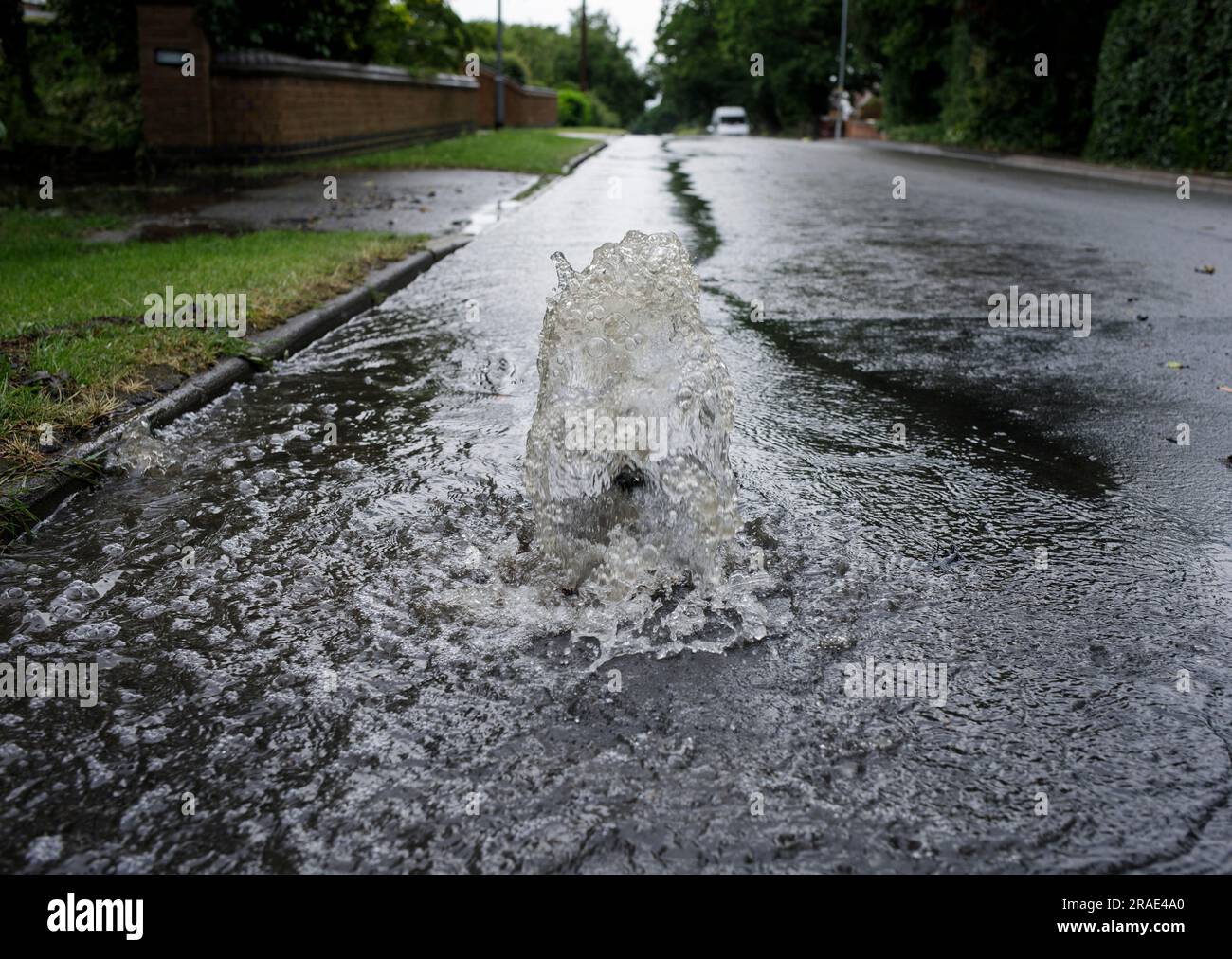 L'acqua piovana si fa strada attraverso uno scarico dopo una tempesta a Redditch, Worcestershire. Foto Stock