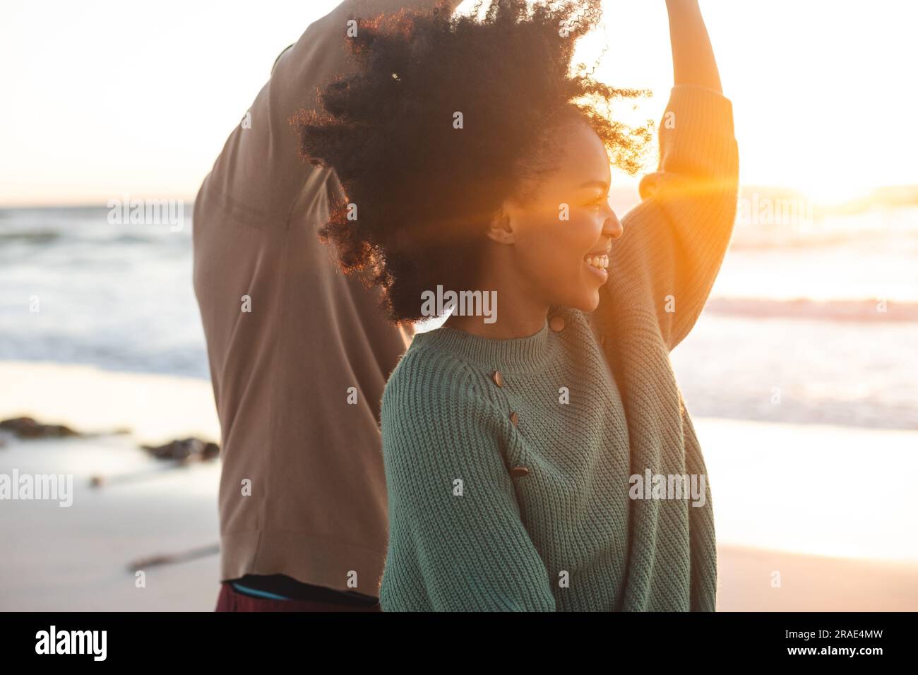 Felice coppia afro-americana che balla e sorride sulla spiaggia soleggiata Foto Stock